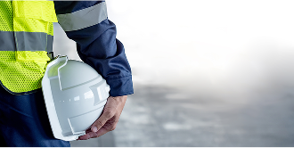 Safety worker holding helmet at side