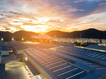 Warehouse and loading dock with solar panels on rooftop at sunset 