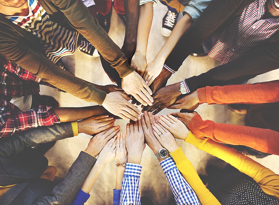 Group of diverse men and women in circle with arms outstretched in front of them overlapping the people next to them