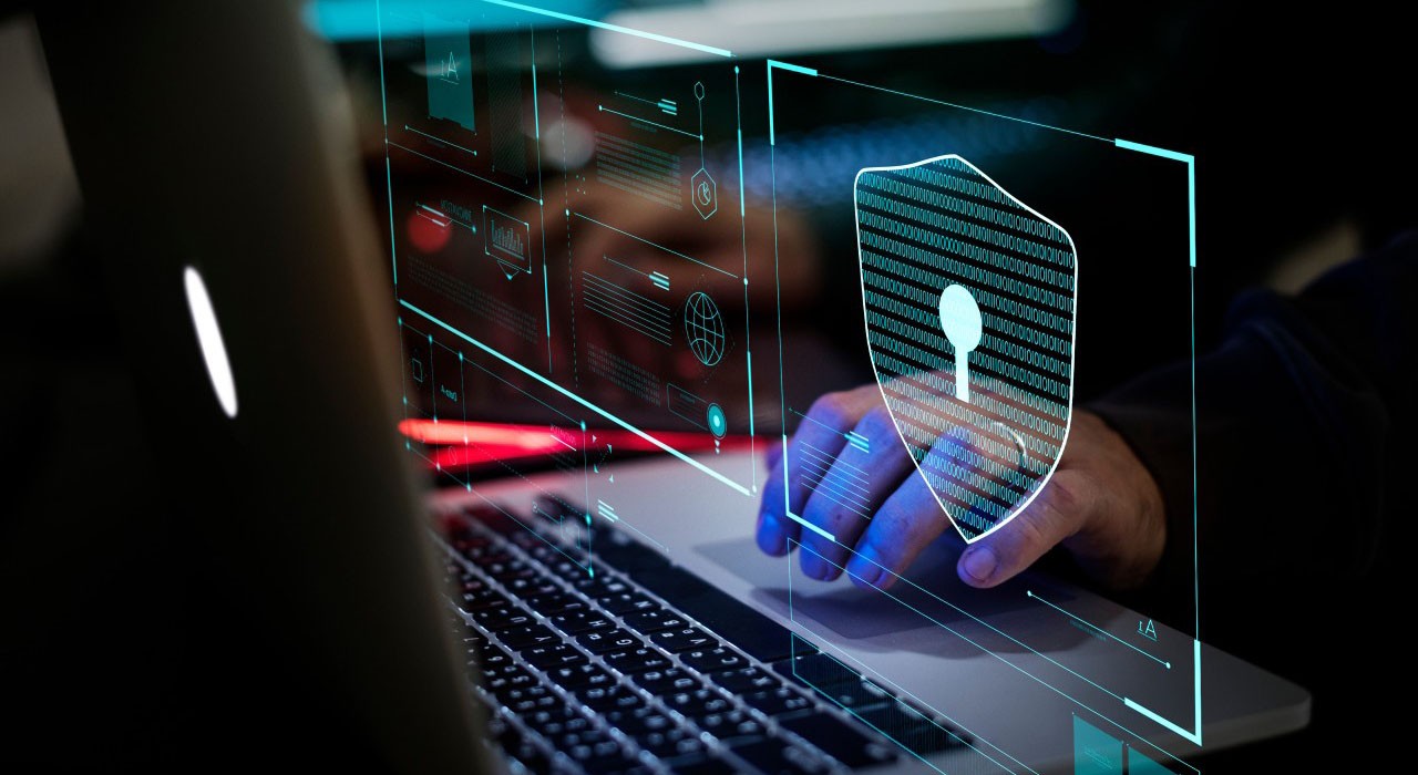 A person using a laptop adorned with a security symbol to represent a focus on secure online practices.