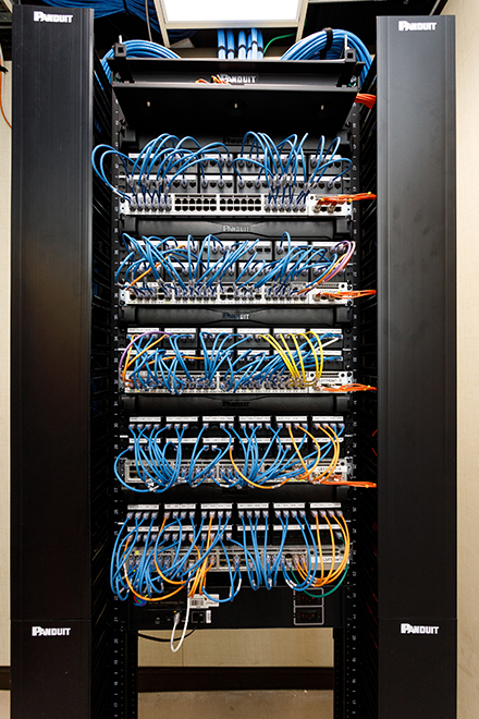 Cable management rack supporting hundreds of short patch cords neatly organized into a rack for easy network mapping as the result of Panduit interventions