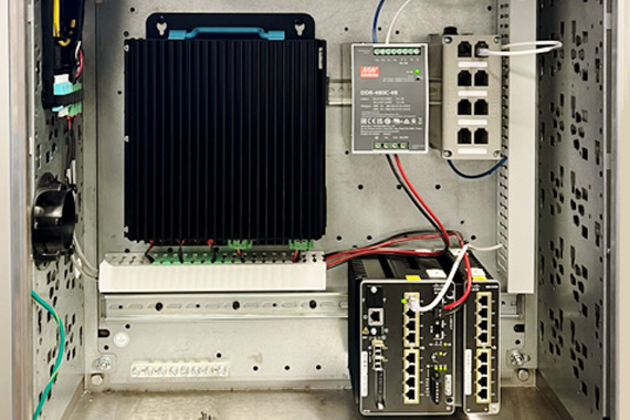 A metal cabinet featuring a power supply and electrical components, including a TrueEdge Wall Mount Cabinet with an FMPS Receiver.