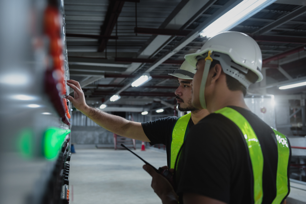 echnician daily check controls system for security functions in service room at factory.