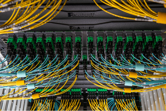An above view close-up of blue and yellow fiber optic cable in server room
