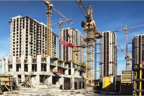 Under Construction skeleton of a high rise building outside with construction cranes