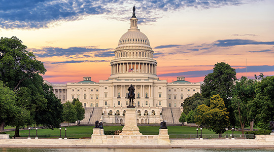 the US capitol building with green trees and a colorful sky